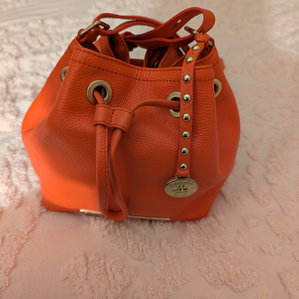 Brahmin Lexi Orange Leather Crossbody Bucket Bag with Gold Hardware And Charm.